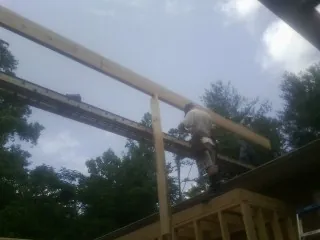 Carpenter setting a ridge beam over a new addition frame — Ice Dam Removal by Roofing Brothers in Milford