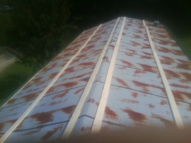 Rusted metal roof panels with new wood purlins before replacement — Storm Damage Roof Repair in Milford by Roofing Brothers